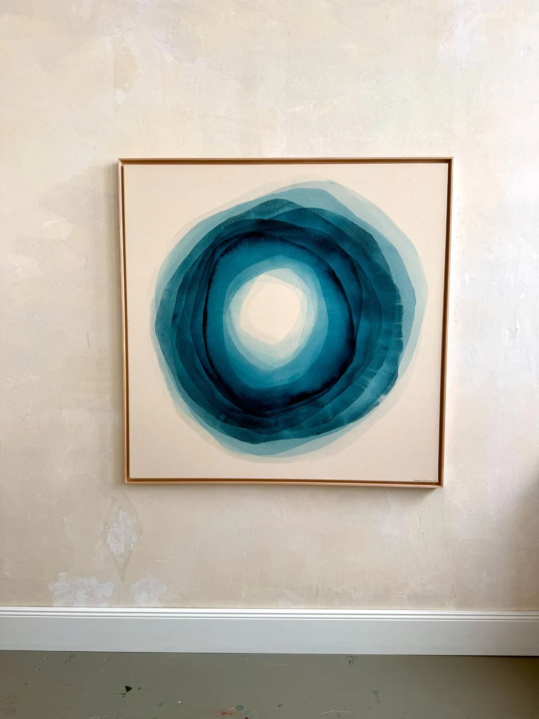 Rond werk van Johanne Bossmann in petrol- en turquoisetinten, in een lichte houten lijst