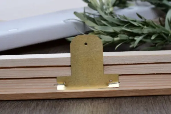Messingplaatje ter bevestiging van een spieraam in een fotokader
