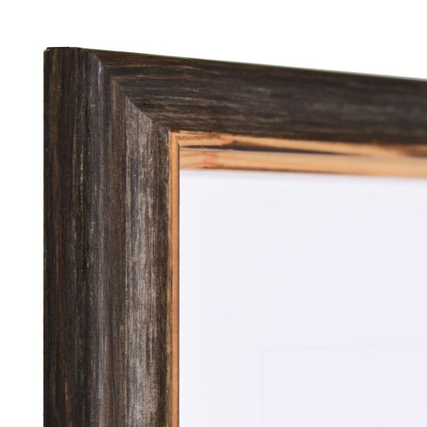 Zicht op de hoek van een donkerbruine houten lijst met een subtiel gebogen massief houten profiel en een verzonken binnenrand in landelijke stijl