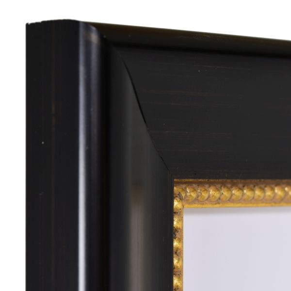 Ansicht der Ecke eines schwarzen, klassischen Bilderrahmens mit goldener Perlkante